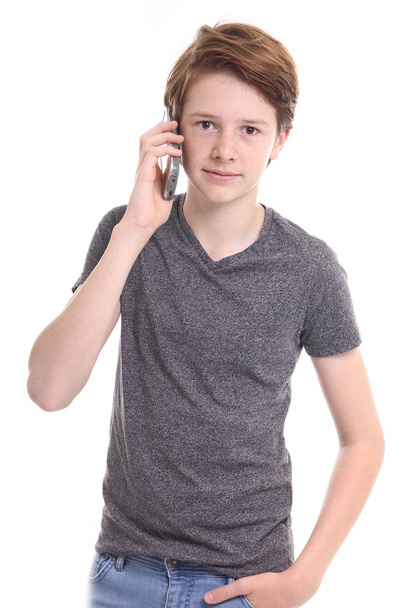 Caucasian teen boy is talking on mobile phone - Фото, изображение