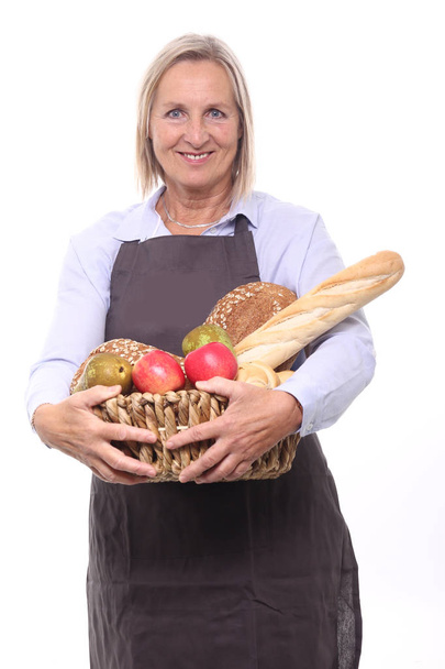 Woman holding basket with different bread and fruits - Zdjęcie, obraz