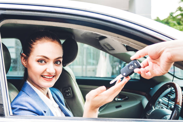 Revendeur donnant des clés de voiture à une nouvelle voiture avec femme d'affaires souriant tout en étant assis dans un concept de voiture car.sale et de location - Photo, image
