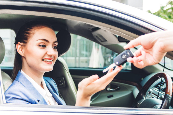 Myynti jälleenmyyjä antaa autonavaimet uuden auton kanssa liiketoiminnan nainen hymyilee istuessaan auto.sale ja vuokra-auton käsite - Valokuva, kuva