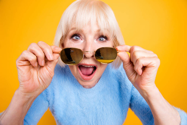 Total sale Old lady looks over the glasses with shocked look an - Foto, Imagen