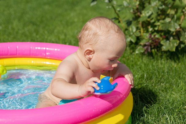 小さな子供は夏にプールで入浴し、膨脹可能な子供のインフレータブルプール - 写真・画像