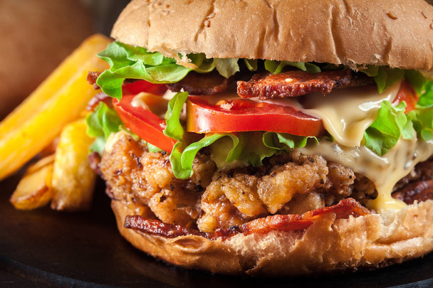 Lahodné hamburger s kuřecím masem, slaninou, rajče, sýr a salát podávaný s hranolky - Fotografie, Obrázek