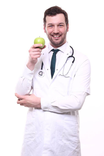 Male doctor wearing special uniform with stethoscope and apple - 写真・画像