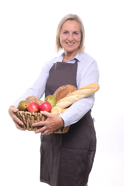 Woman holding basket with different bread and fruits - Foto, afbeelding