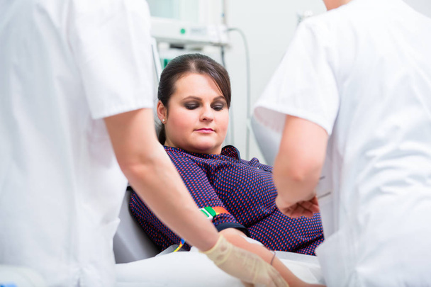 Lääkärit avustaja tarkistaa pääsy naisen veren antaja
 - Valokuva, kuva