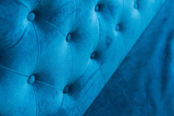 Velour surface of sofa close-up. Coach-type velours screed tightened with buttons. Blue chesterfield style quilted upholstery backdrop close up. - Fotografie, Obrázek
