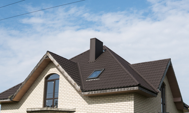 Сучасний дах покритий ефектом плитки ПВХ покритий листами коричневого металу даху
. - Фото, зображення