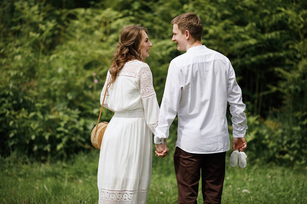 happy pregnant bride and stylish groom with baby shoes outdoor  - Valokuva, kuva