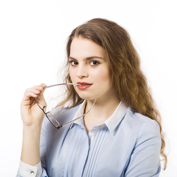 Portrait of smiling young woman dressed in blue shirt posing with glasses on white background  - Zdjęcie, obraz