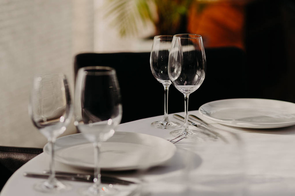 Εορταστική διακόσμηση σερβίρεται δείπνο τραπέζι με μαχαιροπίρουνα με κανείς δεν. Ρύθμιση του πίνακα σε καφετέρια ή εστιατόριο. Φωτεινά χρώματα. Διακόσμηση γάμου σε αίθουσα δεξιώσεων - Φωτογραφία, εικόνα