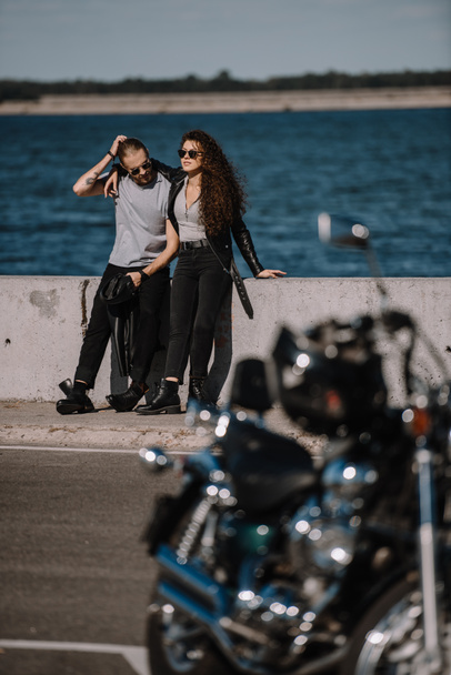 selective focus of young couple with motorcycle on foreground - Photo, Image