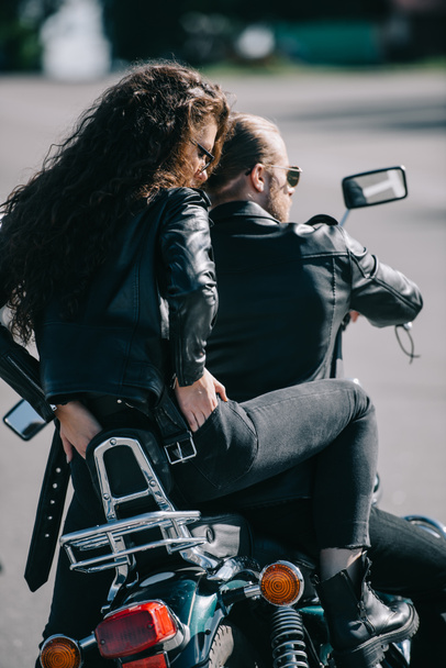 visão traseira do casal de motociclistas em jaquetas de couro preto sentado na motocicleta
 - Foto, Imagem