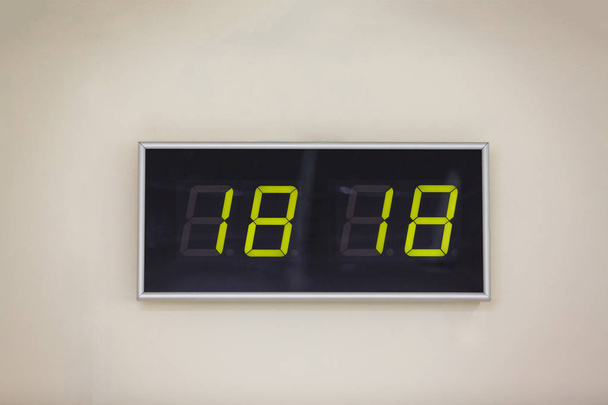 Reloj digital negro sobre fondo blanco que muestra el tiempo dieciocho horas dieciocho minutos
 - Foto, imagen