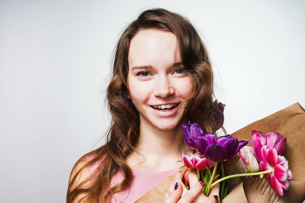a luxurious young woman holding a bouquet of fragrant flowers and posing - Φωτογραφία, εικόνα