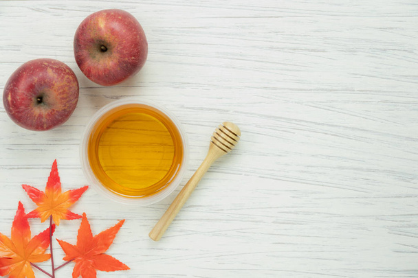 装飾秋の収穫シーズンの新年祭日背景コンセプトのテーブル トップ ビュー撮。フラットはミツバチとオレンジ色のカエデの葉赤いリンゴを置くモダンな素朴な白い木のすべてのオブジェクト. - 写真・画像