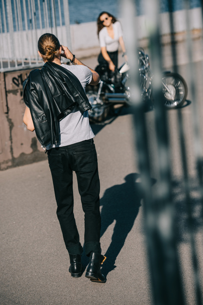 selective focus of biker going to girlfriend with classical chopper motorbike  - Photo, Image