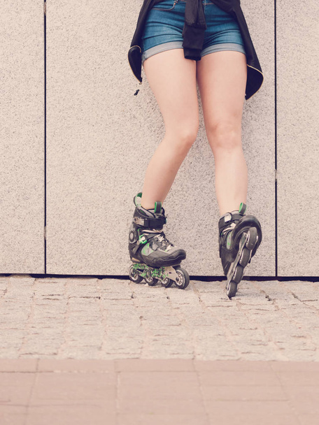 Sexy woman slim legs wearing roller skates standing outside. Sport activity concept. - 写真・画像