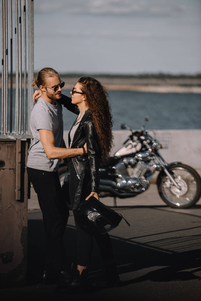 giovani motociclisti che si abbracciano in città con moto d'epoca sullo sfondo
 - Foto, immagini