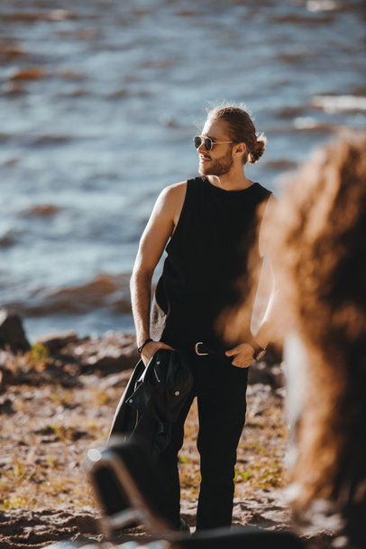 handsome man in sunglasses posing on sea shore - Valokuva, kuva