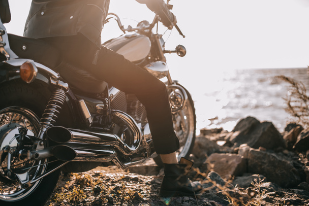 visão de seção baixa do motociclista sentado na motocicleta clássica ao ar livre
 - Foto, Imagem