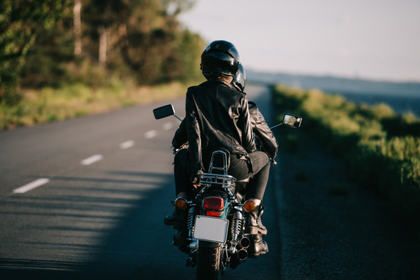 a sisakot, lovaglás motorkerékpár chopper országúton pár hátsó nézet - Fotó, kép