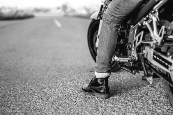 monochrome photo of biker on sport motorcycle on asphalt road - Zdjęcie, obraz