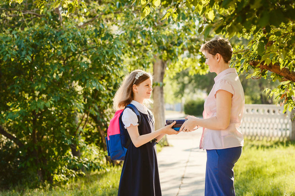 happy mom gives daughter book outdoors - Photo, image