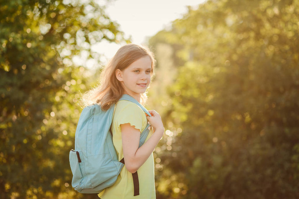 happy ten-year-old girl with a backpack on your back outdoors - 写真・画像