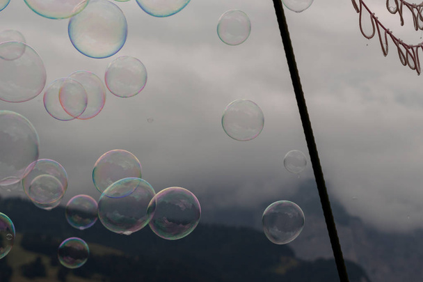 Birden çok sabun köpüğü bir sisli dağ arka plan net ile havadaki - Fotoğraf, Görsel