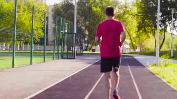 Człowiek działa na ścieżki dla biegaczy na stadionie - Materiał filmowy, wideo