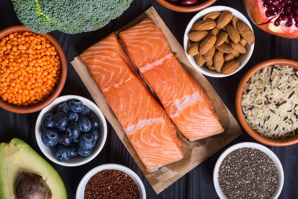 Healthy food with salmon , vegetables , berries , fruit , seeds and almond . Superfood - Фото, зображення