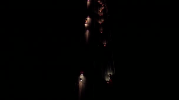 Légi Heli felvétel: Pillantsd gépkocsi fényszóró és a hátsó lámpák elfoglalt amerikai államközi főút fölött repül. Autók, utazás, félig teherautók hajózás, ingázók vezetés az autópálya mentén - Felvétel, videó
