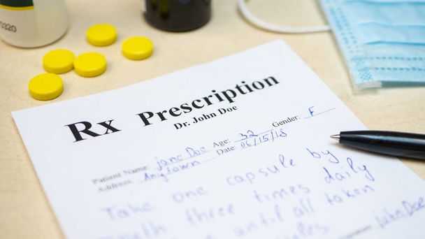 Receptę na pigułki tabletka lub leki na stole z butelki i żółte tabletki lub pigułki i maski medyczne - Zdjęcie, obraz