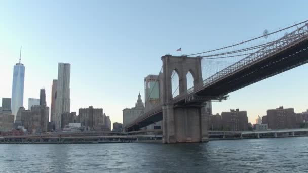 Niedriger Blickwinkel, Nahaufnahme: Erstaunliche Sightseeing-Kreuzfahrt auf dem East River entlang berühmter New Yorker Wolkenkratzer in Richtung der ikonischen Brooklyn Bridge und Wohnhochhäuser in kleiner deutscher Nachbarschaft - Filmmaterial, Video
