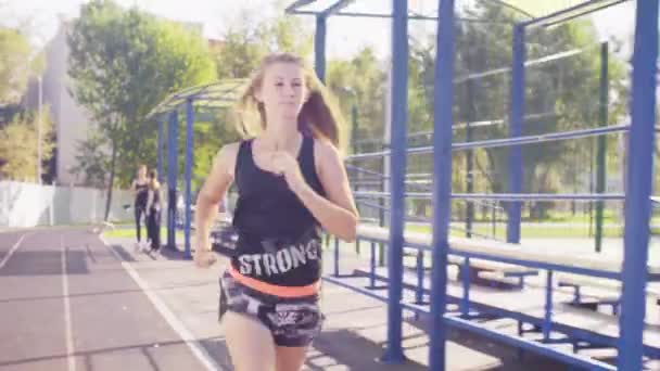 Young woman running at the sports ground - Filmmaterial, Video
