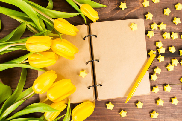 Caderno vintage com tulipas amarelas e estrelas de papel amarelo, flat lay
 - Foto, Imagem