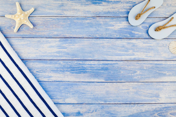 Kreatywnych mieszkanie świeckich koncepcja lato wakacje. Widok z góry ręcznik flip flops muszle i rozgwiazdy na tle pastel niebieski desek z miejsca kopii w stylu rustykalnym rama szablon tekst - Zdjęcie, obraz