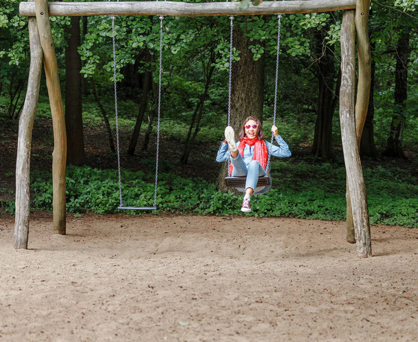 楽しんで都市公園における若い幸せな女のライフ スタイルでシーソー スイング - 写真・画像