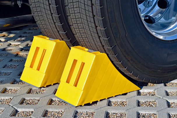 Gele chocks achter het stuur van een geparkeerde vrachtwagen  - Foto, afbeelding