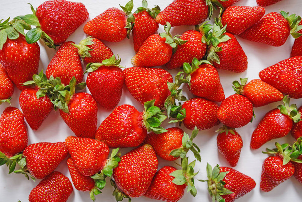 Νωπών φράουλα. Φράουλες σε άσπρο φόντο σκυροδέματος. Συγκομιδή των βιολογικών τοπικών φράουλες. - Φωτογραφία, εικόνα