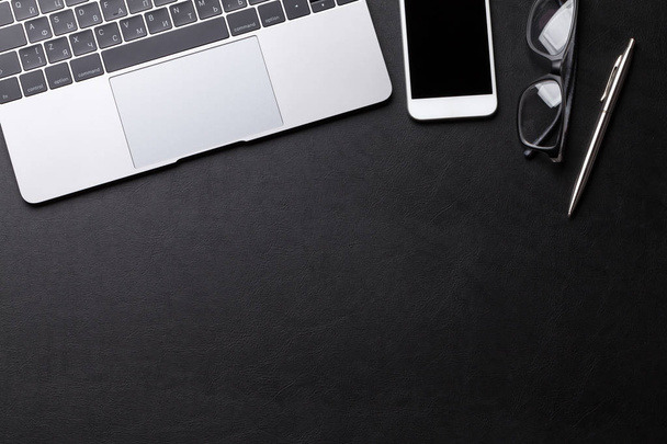 Fournitures de bureau, smartphone et ordinateur portable sur table en bois noir. Pose plate. Vue de dessus avec espace pour votre texte
 - Photo, image