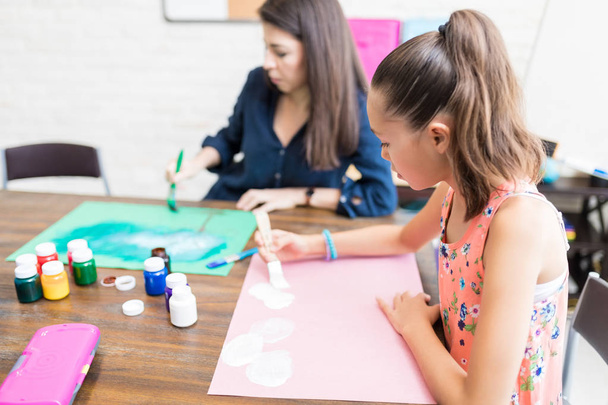 Lány és anya rajz papírok asztalhoz ház színező - Fotó, kép