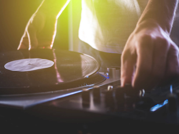 DJ handen op professionele muziek apparatuur dek vinyl record platenspeler en tijdcode - Foto, afbeelding