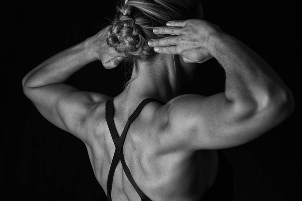 Fit woman with shaped muscles on her back in artistic conversion - Фото, изображение