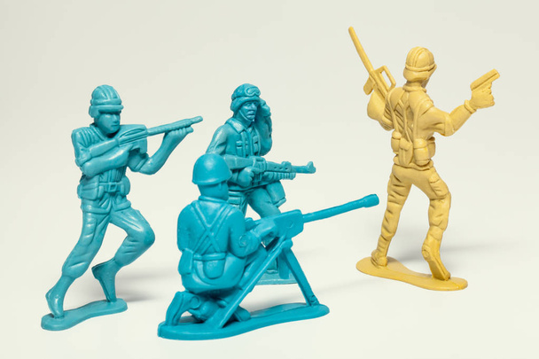 macro-groep van plastic speelgoed soldaten met geweren nemen gevangene de vijandelijke soldaat - Foto, afbeelding