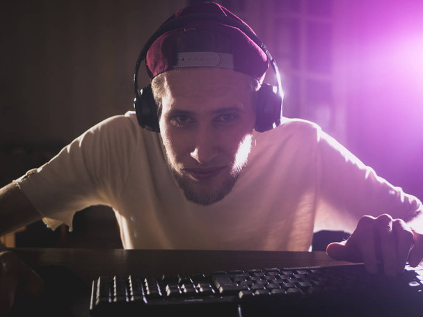 Zárja be a videó lejátszás game egy számítógép otthon az éjszaka szakállas fiatalember portréja - Fotó, kép