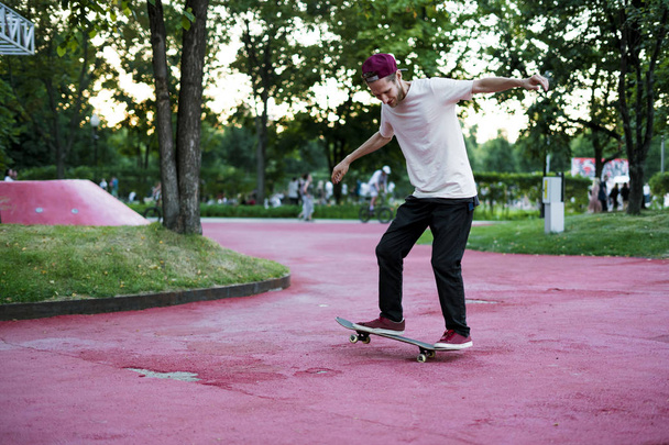 male skateboarder doing crazy tricks in the city street park on a summer day - Photo, Image