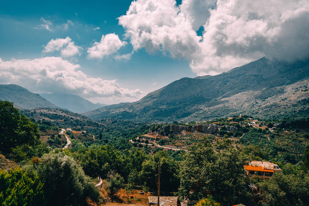 View on mountain with low hanging clouds and green trees. South Crete neat Rethymno, Greece - 写真・画像