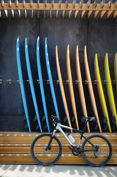 Ποδηλάτων μπροστά από ομάδα ιστιοσανίδες για ενοικίαση κατάστημα surf - Φωτογραφία, εικόνα